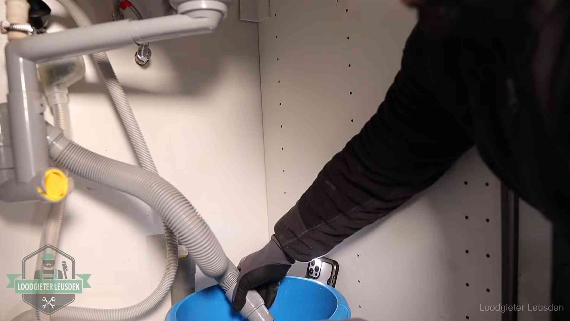 Afvoerslang loopt leeg in een emmer onder de gootsteen in Leusden, een klus die je zelf kunt doen