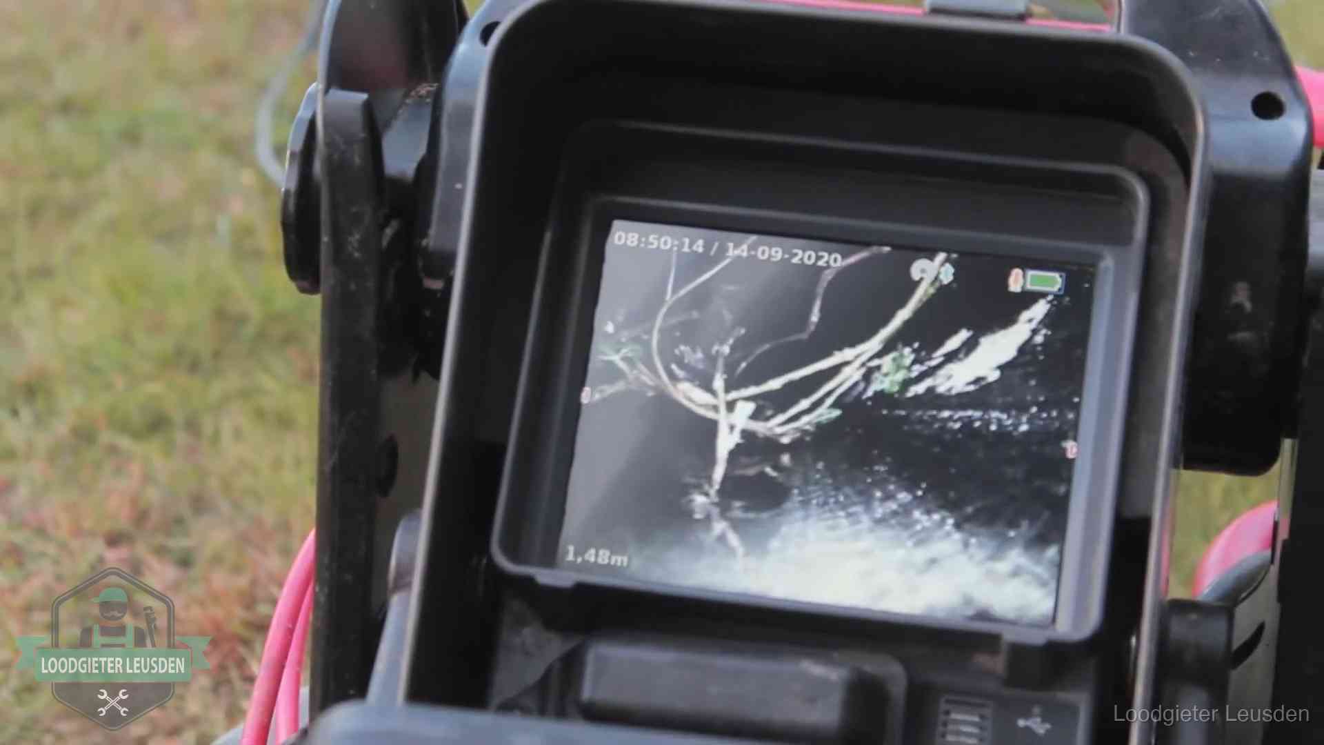 Monitor van een rioolcamera toont wortelingroei in de rioolbuis bij een woning in Leusden