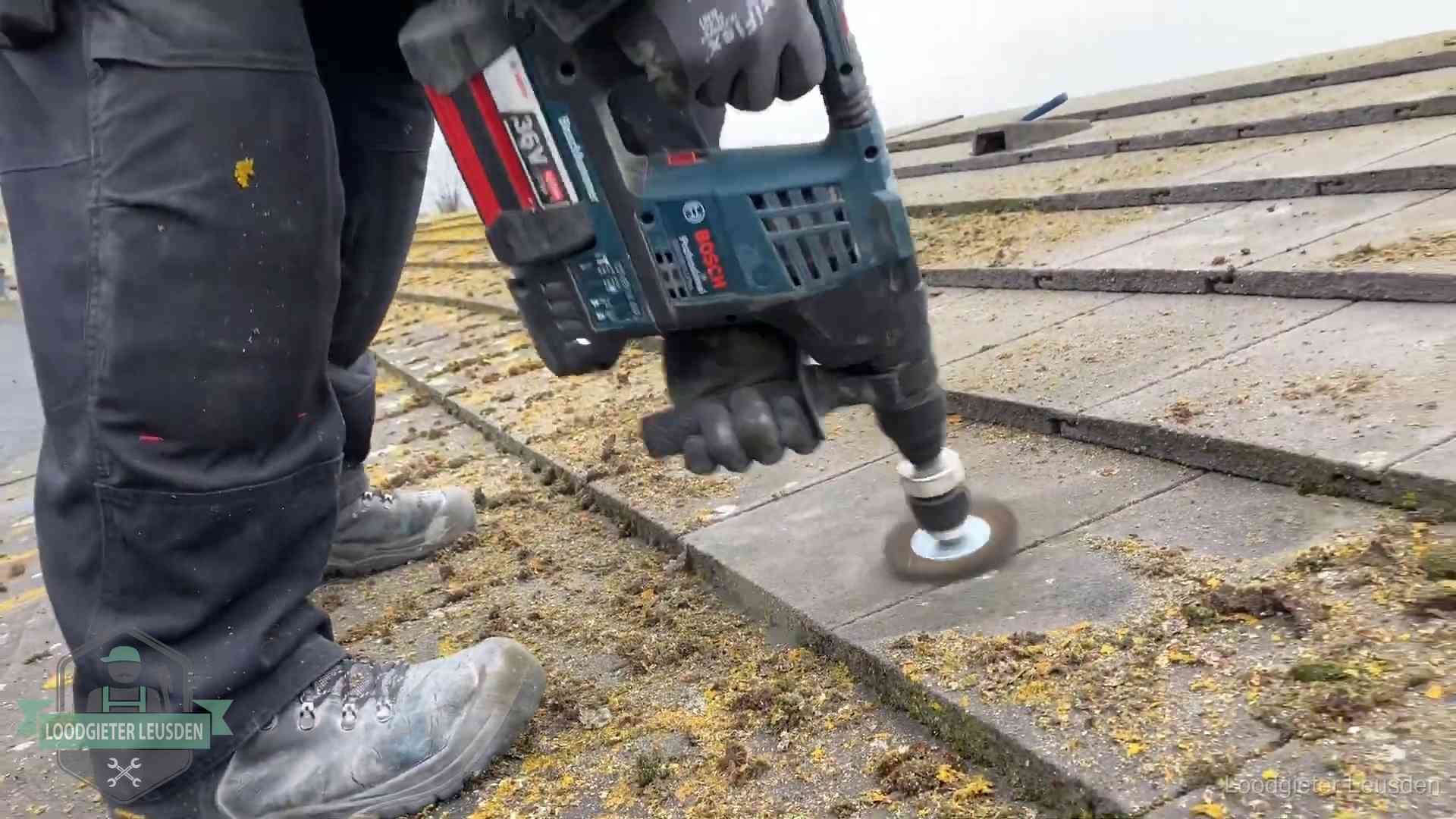 Betonnen dakpannen worden machinaal gereinigd tijdens dakonderhoud in Leusden