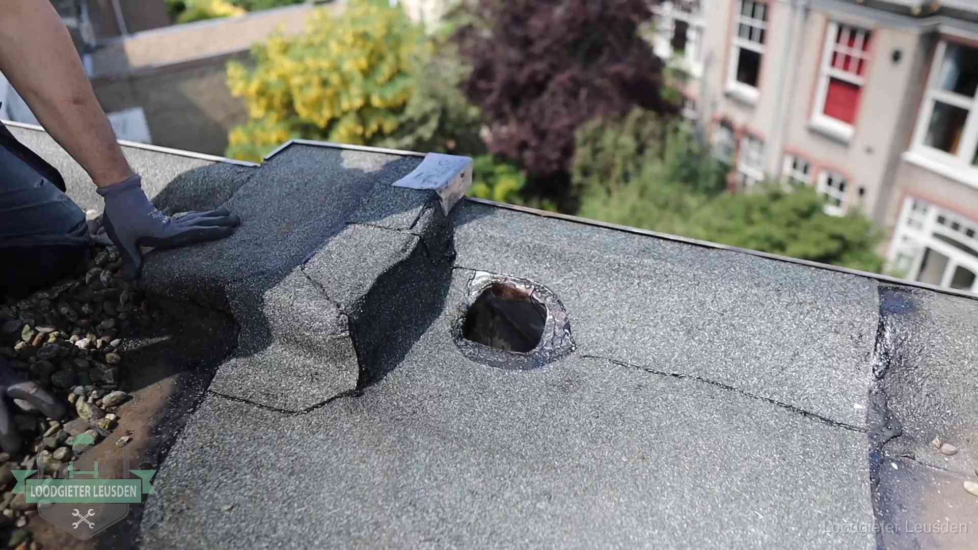 Loodgieter inspecteert een beschadigd bitumen plat dak tijdens een daklekkage-inspectie in Leusden