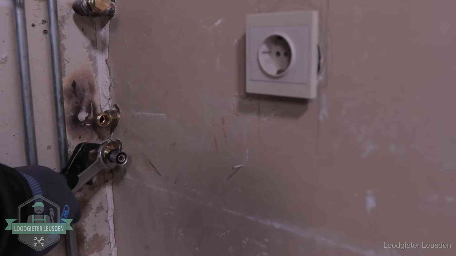Monteur draait een perskoppeling vast op een leidingaansluiting in Leusden