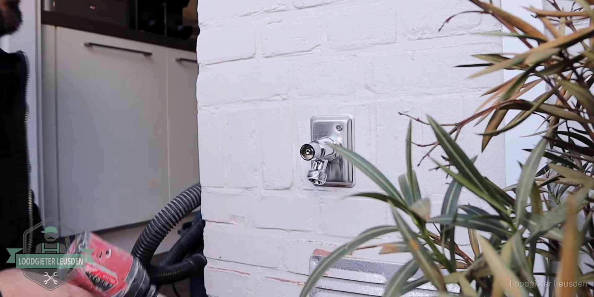 Chromen kraan op een muurplaat bij een woning in Leusden, dichtdraaien is stap een van de lektest