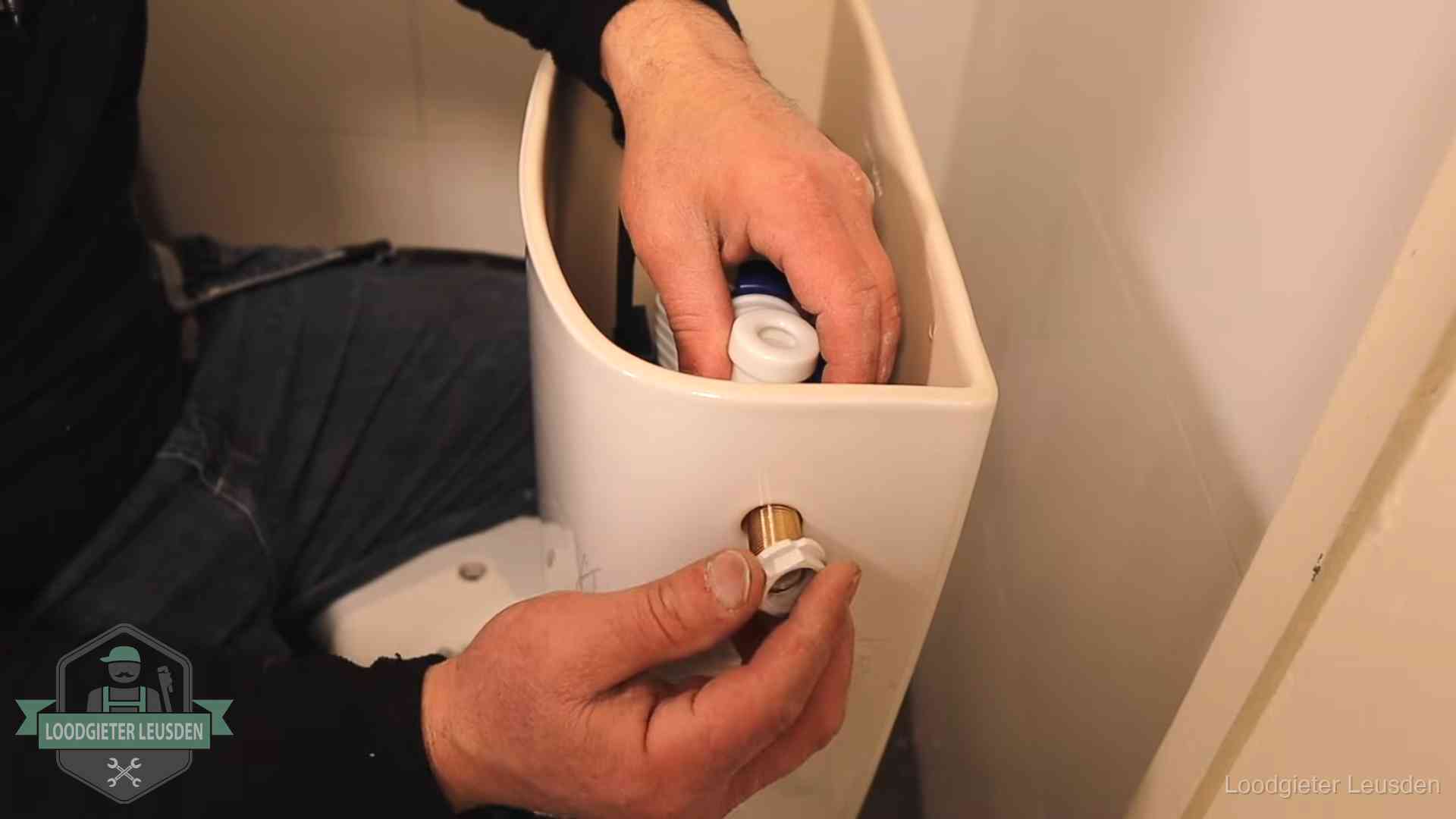 Loodgieter monteert de vlotterkraan van een stortbak bij een toilet in Leusden