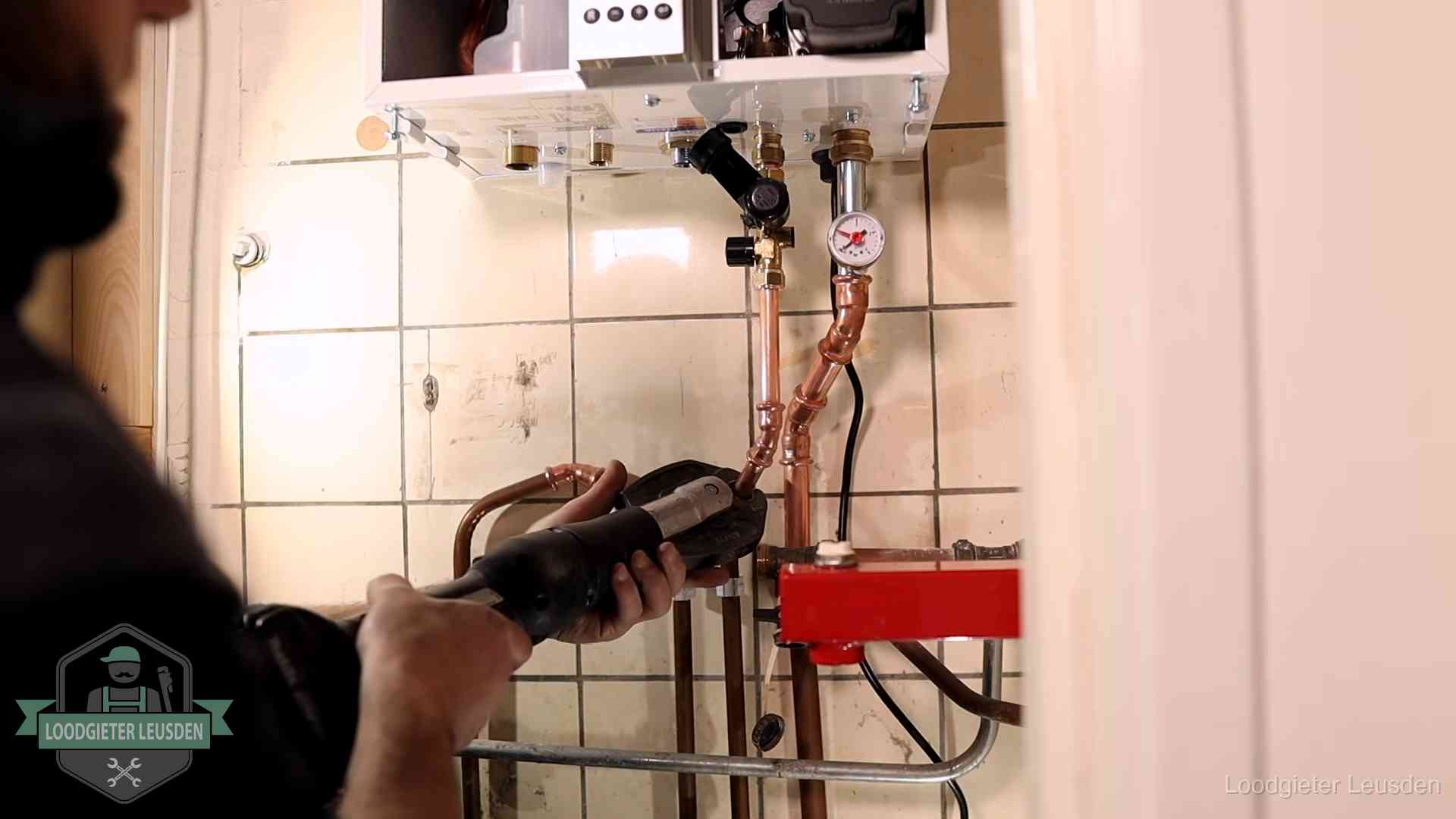 Cv-ketel onderhoud in Leusden Monteur werkt aan de leidingen onder een cv-ketel in Leusden