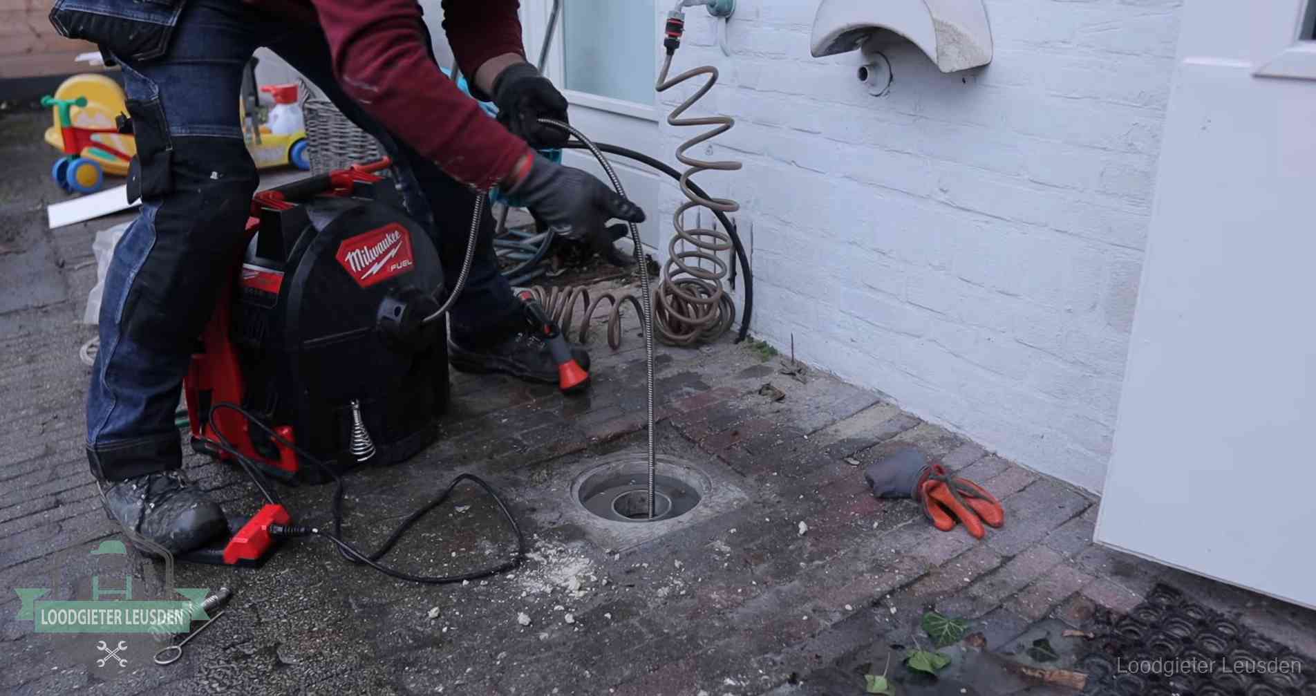 Ontstoppingsputje in de bestrating naast de gevel van een woning in Leusden