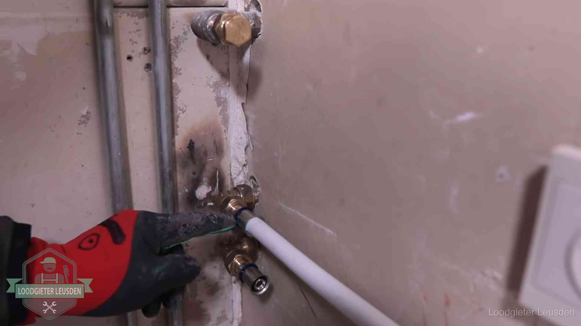Loodgieter wijst de persfitting op nieuwe muuraansluitingen aan in een woning in Leusden