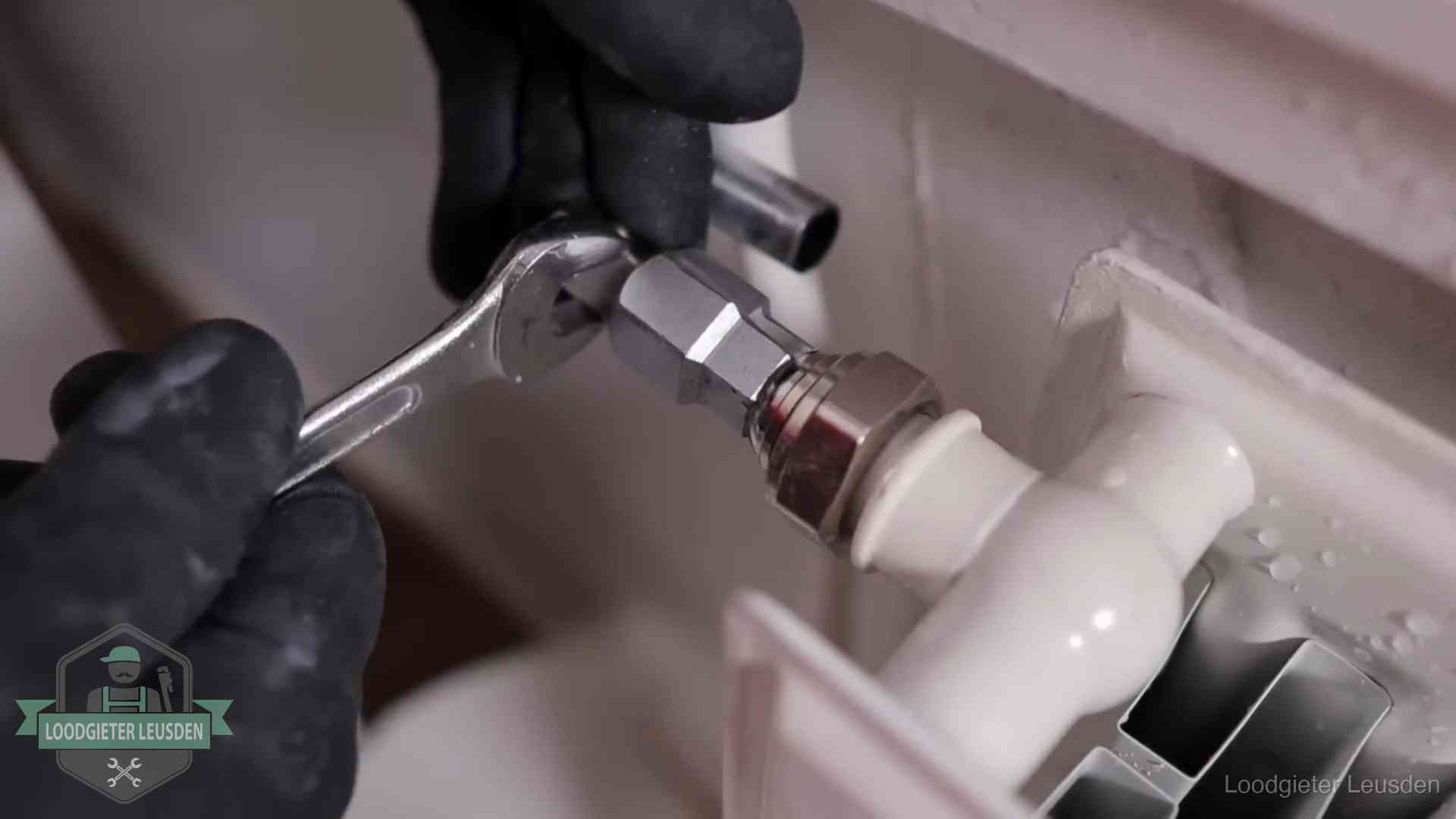 Radiatoren en waterzijdig inregelen in Leusden Steeksleutel draait een wartelkoppeling op een radiatorkraan aan in Leusden
