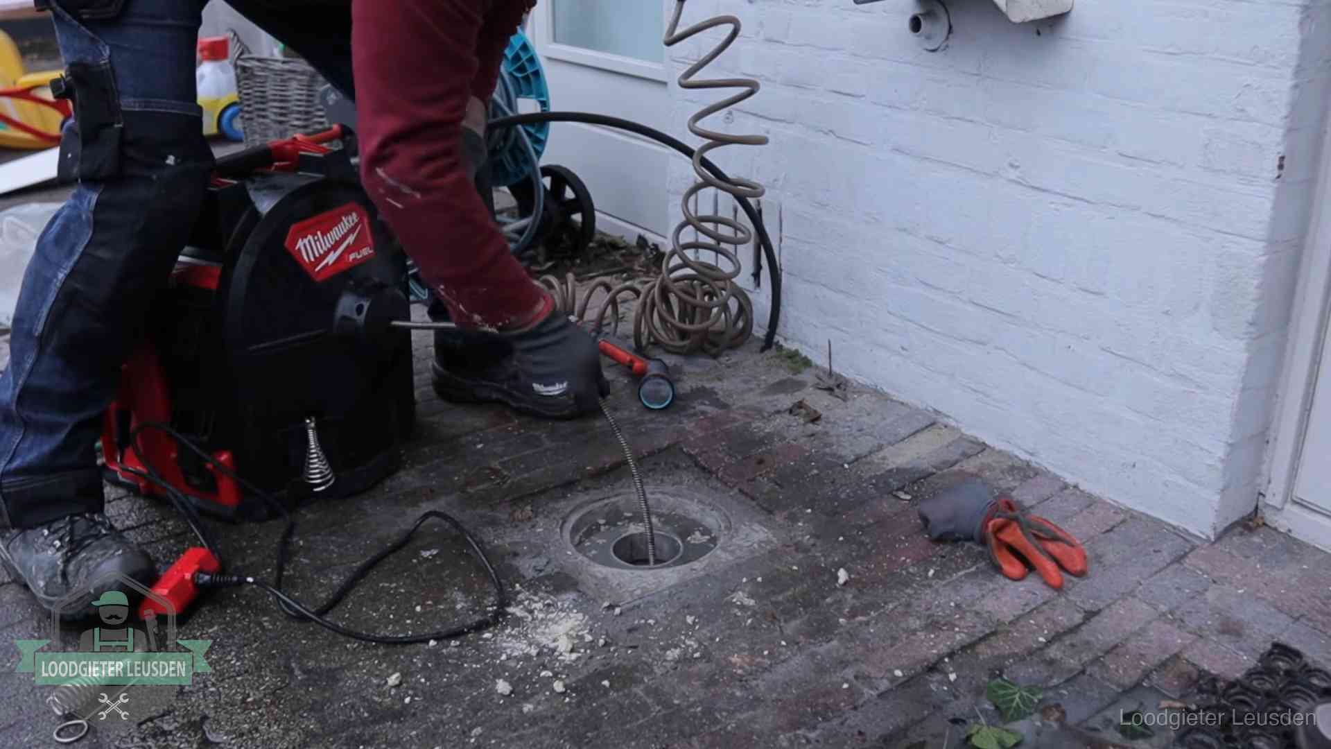 Spiraalmachine bij een ontstoppingsputje in de bestrating in Leusden
