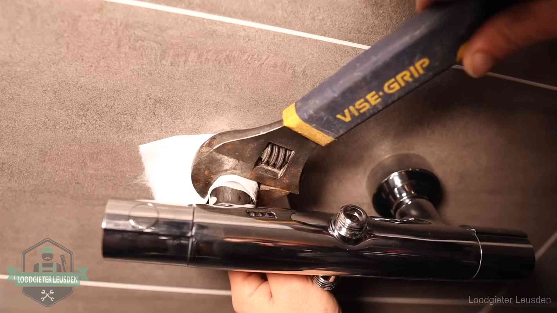 Loodgieter draait met beschermd gereedschap een kraan vast bij een spoedklus in Leusden