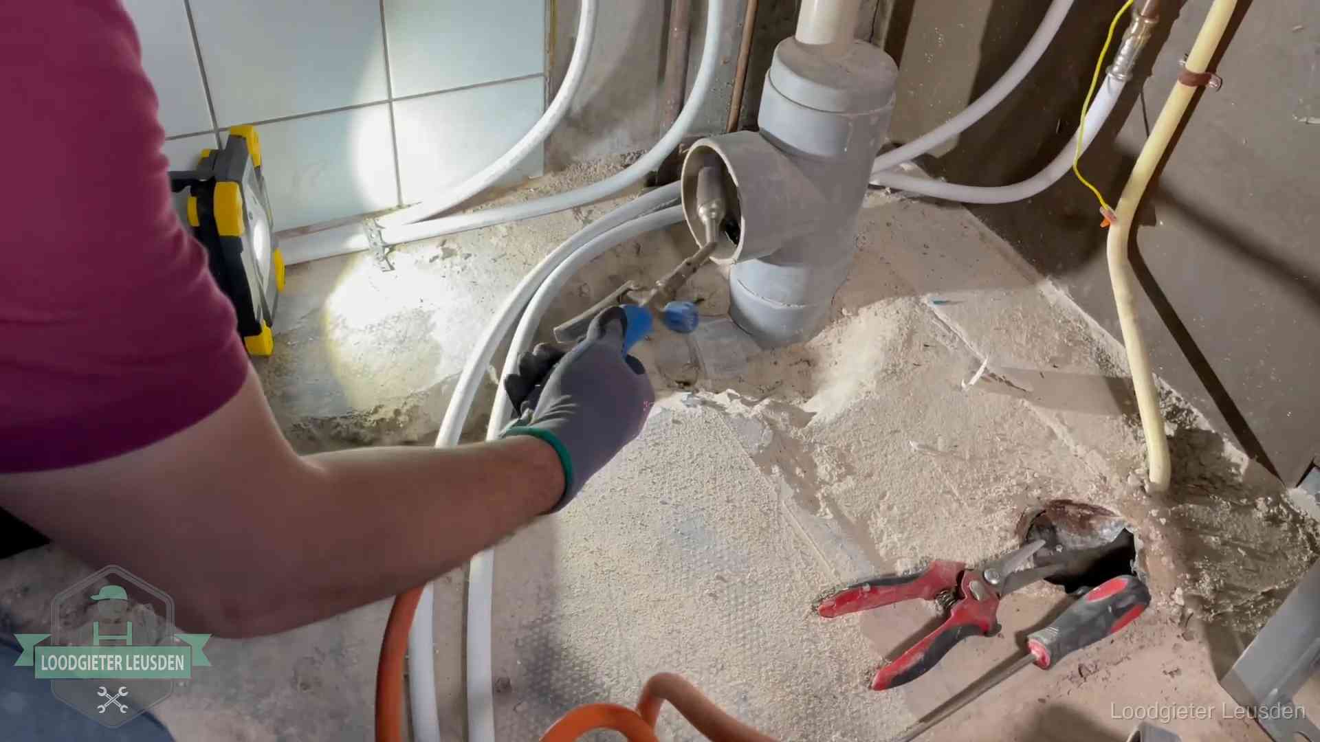 Loodgieter werkt aan leidingen bij een pvc-standleiding in een appartement in Leusden