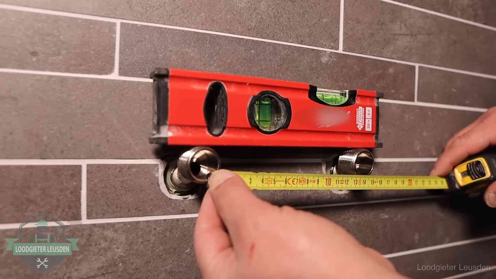 Waterpas en duimstok bij kraan-aansluitpunten in een badkamer in Leusden