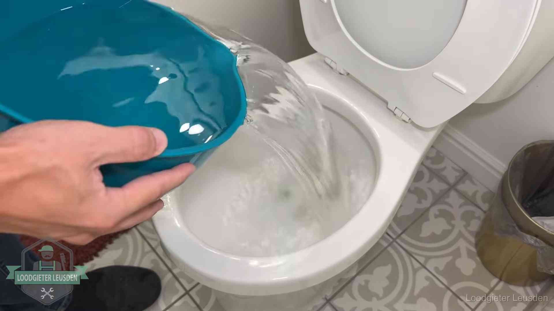 Warm water wordt voorzichtig in de wc-pot gegoten in Leusden
