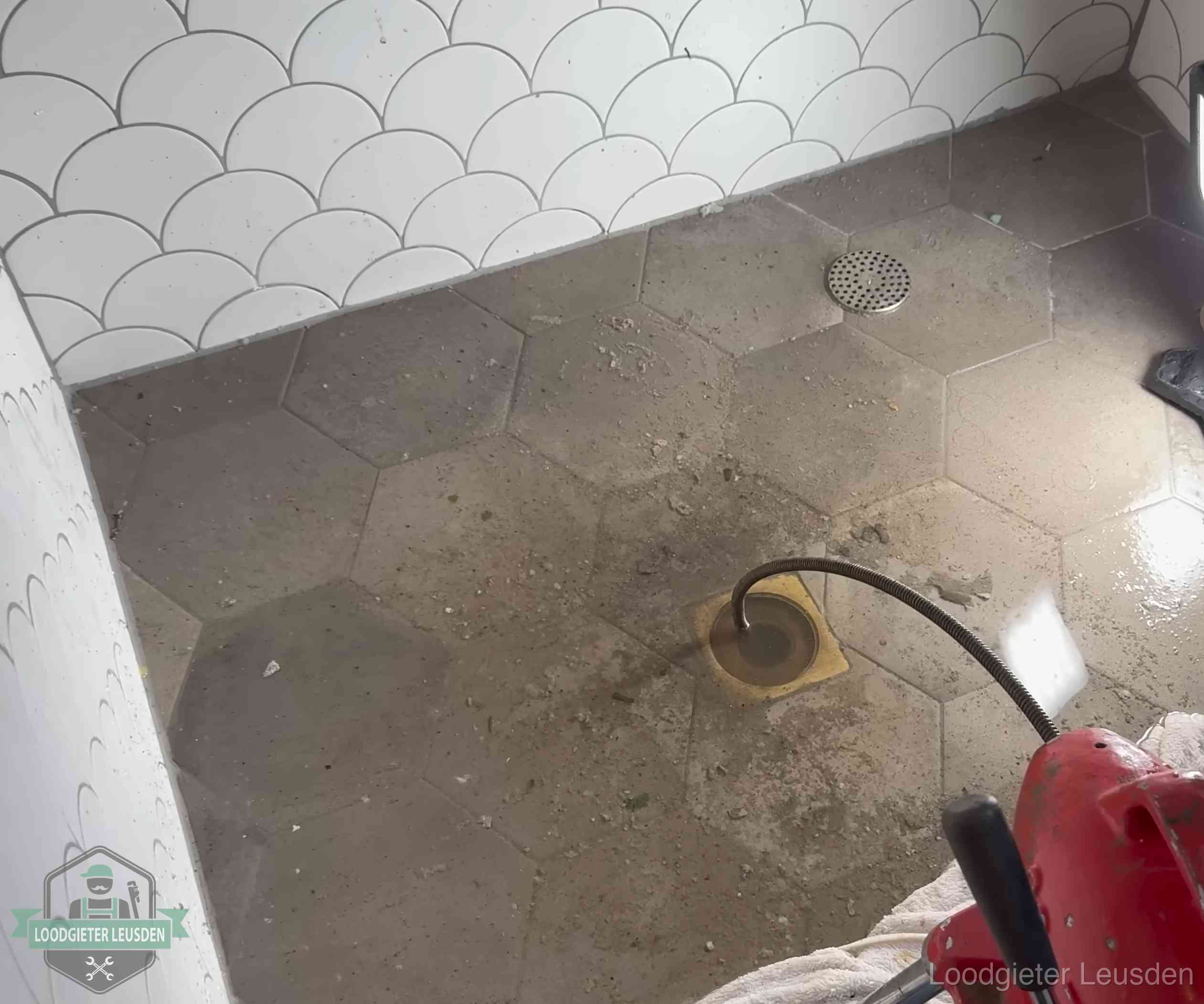 Vloerput met waterslot in een badkamer in Leusden, een bron van stank als het waterslot droogstaat