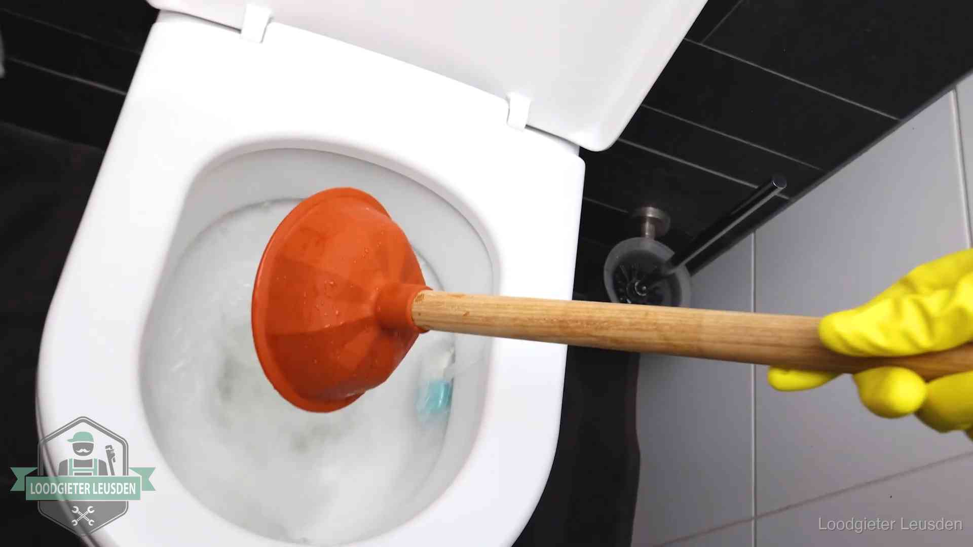 Plopper wordt in de wc-pot gedrukt bij het ontstoppen van een toilet in Leusden