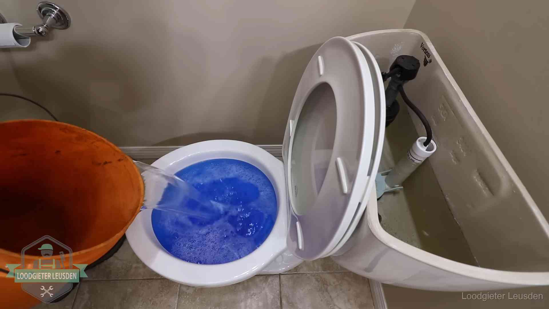 Water bij de wc-pot wordt met een emmer weggewerkt om schade te beperken in Leusden